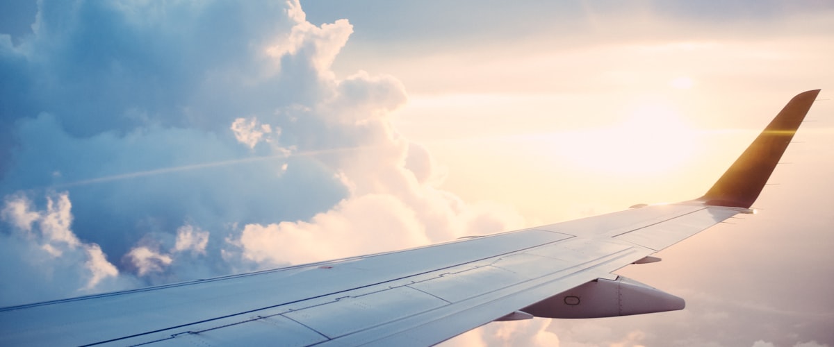 Aircraft wing above clouds - travel health planning